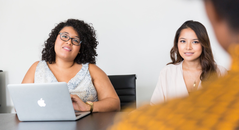 Lady at a computer interviewing someone